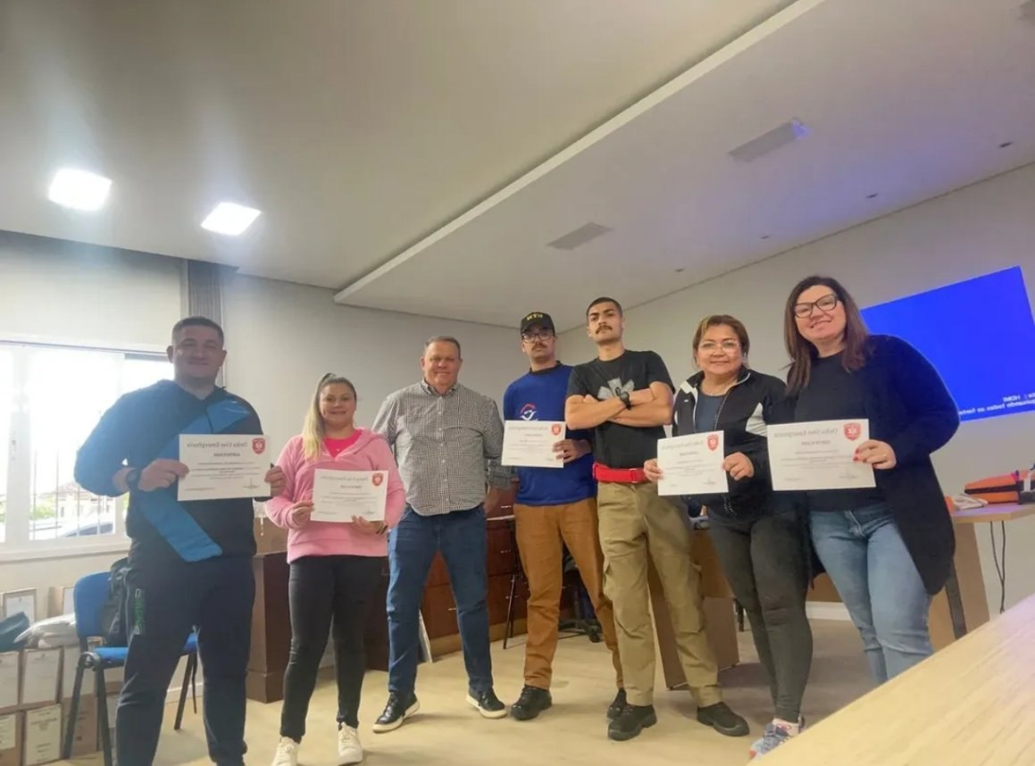 Turma de alunos posando com os certificados de um treinamento da Delta Uno